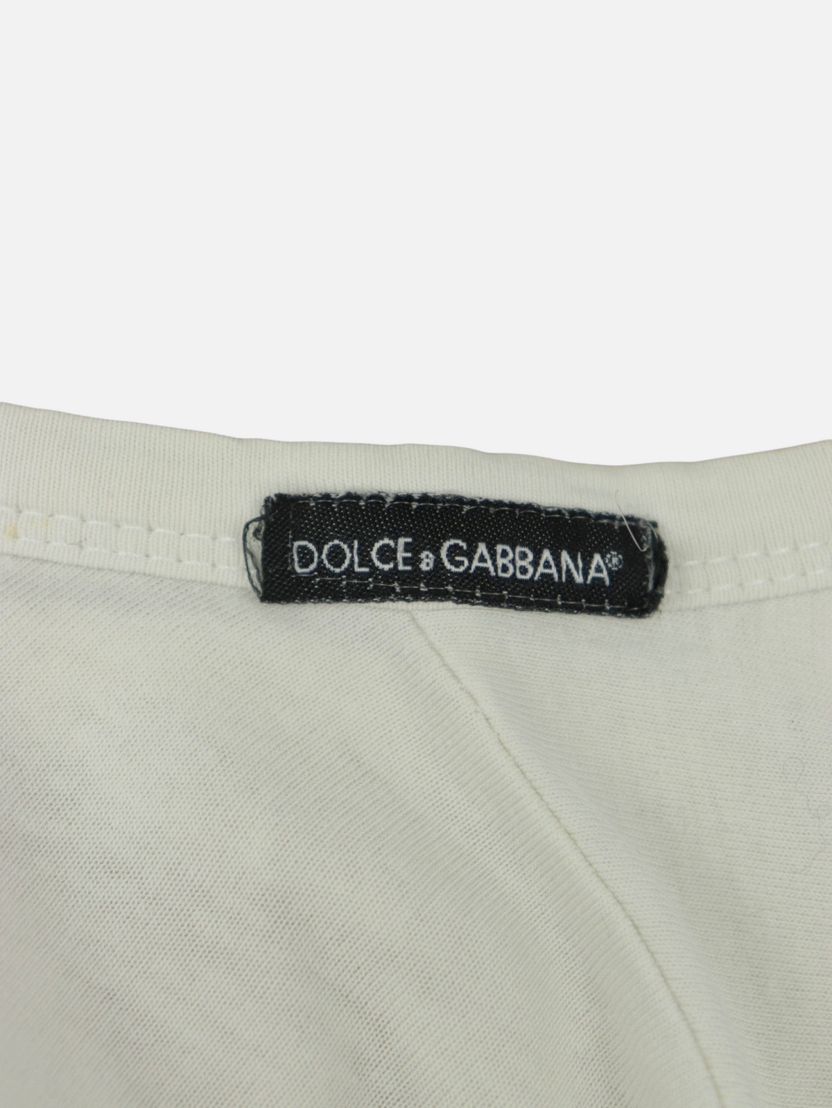 Etiqueta de marca Dolce & Gabbana en camiseta blanca vintage de Alabama Vintage, estilo Y2K de los años 2000.